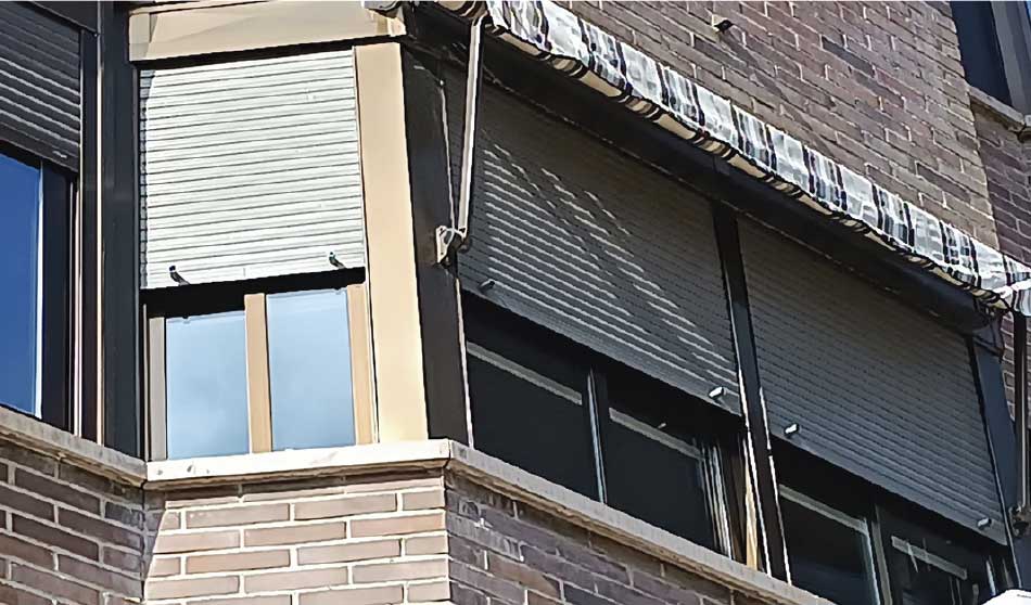 Instalación de persianas en una ventana de aluminio en un edificio de ladrillo