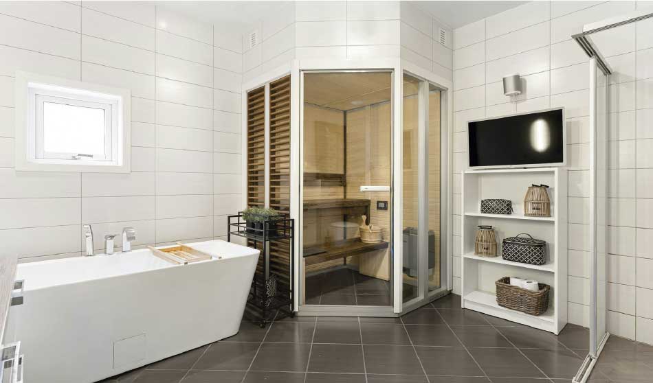 Baño moderno con mamparas de vidrio, bañera y estantería con toallas