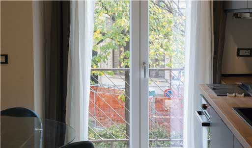 Baño moderno con mamparas de vidrio, bañera y estantería con toallas